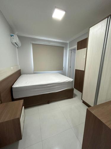 a small bedroom with a bed in a room at Apartamento 603, lindo, climatizado, completo in Piratuba