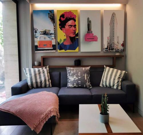 a living room with a blue couch and some pictures at Design Studio in Roma Norte - Walk Everywhere in Mexico City