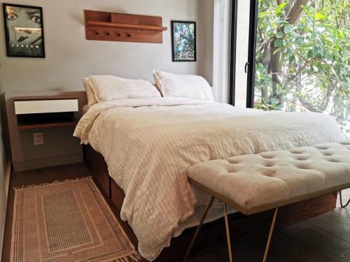 a bedroom with a bed with a large window at Design Studio in Roma Norte - Walk Everywhere in Mexico City