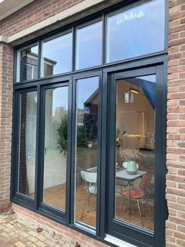 a window in a brick building with a table and chairs at IJsselliefde in Kampen