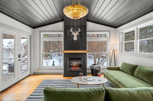 a living room with a green couch and a fireplace at Launchpoint Lodge: Entire Hotel in Lincoln