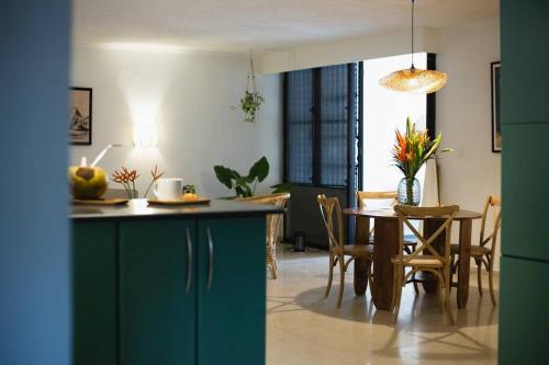 cocina y comedor con mesa y sillas en Architect’s tropical apt with beautifull garden en Panamá