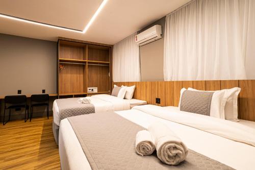 a hotel room with two beds with towels on them at You Stay at Vila Olimpia - The World in Sao Paulo