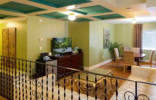 a living room with green walls and a dining room at Grant Hall Hotel in Moose Jaw