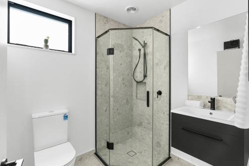 a bathroom with a shower and a toilet and a sink at Modern Sunny 3Bed 2.5Bath in Christchurch