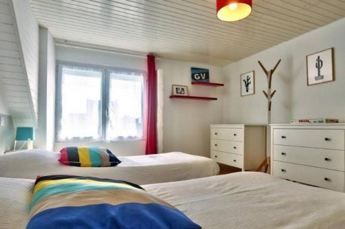 een slaapkamer met 2 bedden en een raam bij Maison avec Jardin,Terrasse,bar,baby foot 4-6 pers in Le Guilvinec