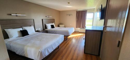 a hotel room with two beds and a window at Red Lion Inn & Suites Pontoon Beach in Pontoon Beach
