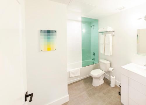 a white bathroom with a toilet and a sink at The Laundry Rooms Augusta in Hamilton