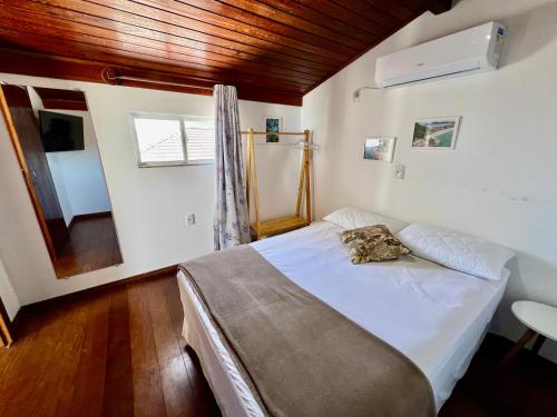 ein Schlafzimmer mit einem großen Bett in einem Zimmer in der Unterkunft Acorde Com o Cenário Beira Mar - Coberturinha in Bombinhas