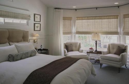 a bedroom with a large bed and two chairs at Lonsdale House Luxury Apartments in Ulverston