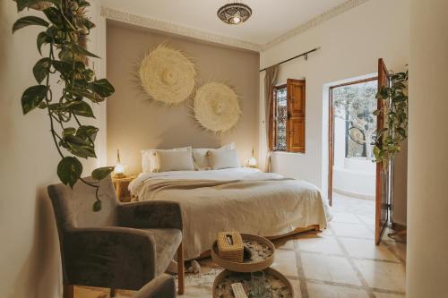 een slaapkamer met een bed en een stoel bij Riad Dar Coram in Marrakesh