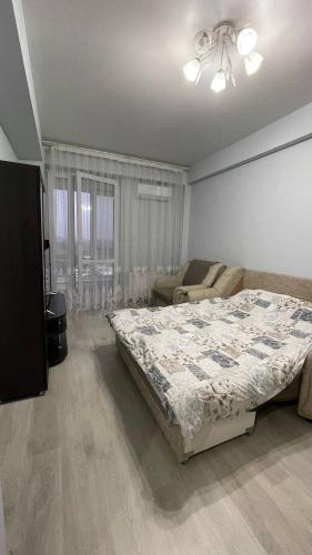 - une chambre avec un lit et un canapé dans l'établissement Dendrarium Apart, à Chişinău