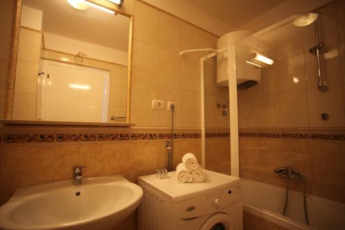 a bathroom with a sink and a toilet and a mirror at Residence Art Split in Podstrana