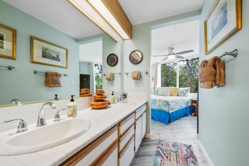 a bathroom with two sinks and a large mirror at Mauna Loa Village with Pools, Tennis & Pickleball in Kailua-Kona