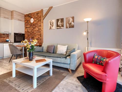 a living room with a couch and a chair and a table at Gdańsk Central Business Apartments with Parking by Rentujemy in Gdańsk