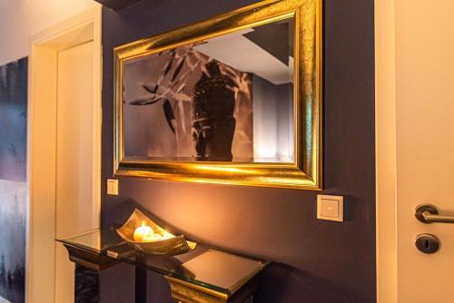 a mirror on a wall with a bowl on a glass table at Luxurious Apartment with Sauna in Cologne