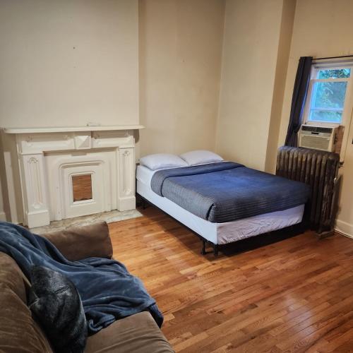 ein Wohnzimmer mit 2 Betten und einem Kamin in der Unterkunft New York City GuestHouse in New York