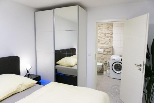 a bedroom with a bed and a bathroom with a washing machine at Charmante und stilvolle Wohnung in Alfter