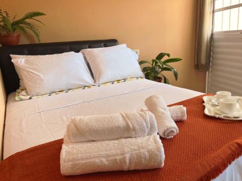 a bedroom with a bed with towels on it at Suite Nete Andrade Ponta De Mangue in Maragogi