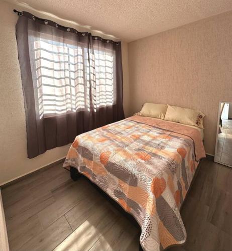 a bedroom with a bed and a large window at Depa Meraki More in Morelia