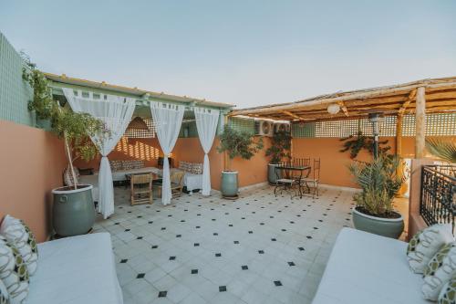 d'une terrasse avec des plantes en pot et une table. dans l'établissement Riad Dar Coram, à Marrakech