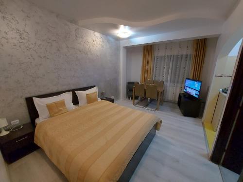 a hotel room with a bed and a television at Aparthotel La Manastire in Sinaia