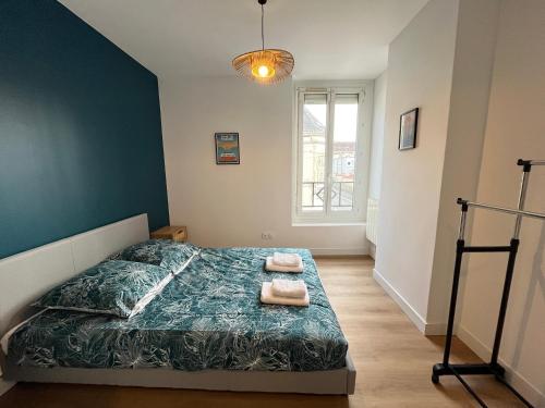 une chambre avec un lit avec deux serviettes dessus dans l'établissement Le Pâtis - Proche Gare - Centre ville - 4 pers, au Mans