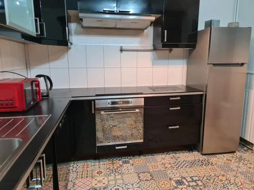 une cuisine avec une cuisinière et un réfrigérateur dans l'établissement Appartement avec jacuzzi, sauna, jardin, à Bondy