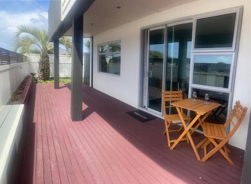 a wooden deck with a table and chairs on a house at Saint Aubyn Retreat in New Plymouth