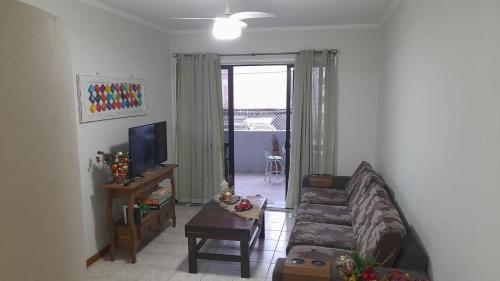 a living room with a couch and a tv at Meu verao em ITAPEMA in Itapema