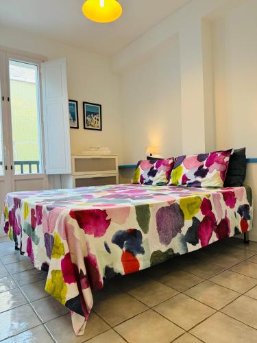 a bedroom with a bed with a colorful blanket at Oltremare Marzamemi in Marzamemi