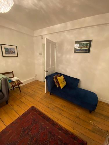 a living room with a blue couch and wooden floors at Trendy 1BD Flat - 5 mins to Cambridge Heath! in London