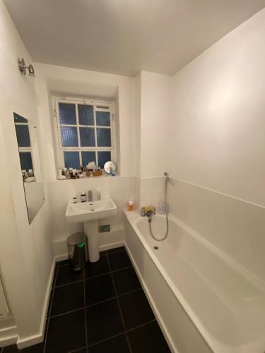 a bathroom with a sink and a bath tub and a sink at Trendy 1BD Flat - 5 mins to Cambridge Heath! in London