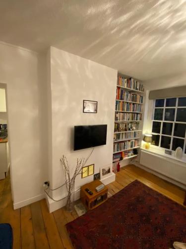 a living room with a flat screen tv on a white wall at Trendy 1BD Flat - 5 mins to Cambridge Heath! in London