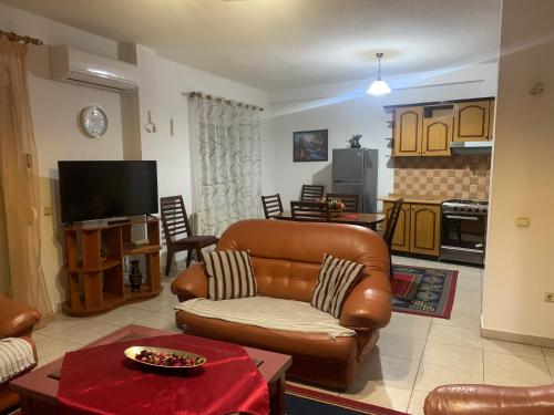 a living room with a leather couch and a television at Lovely flat in the heart of Korca #7 in Korçë