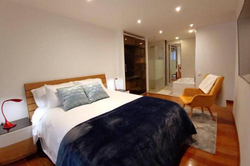 a bedroom with a large bed and a bathroom at Bespoke Suite, Unique Location, Complementary Airport Pick Up in Bogotá