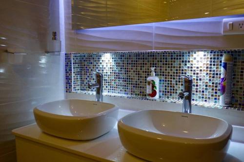 La salle de bains est pourvue de deux lavabos et de deux robinets. dans l'établissement Bespoke Suite, Unique Location, Complementary Airport Pick Up, à Bogotá