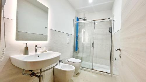 a bathroom with a sink and a toilet and a shower at Flamingo Suites in Marina di Camerota