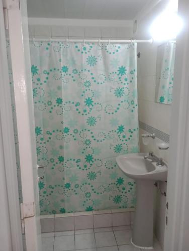 a bathroom with a shower curtain and a sink at departamento tejedor in Mar del Plata