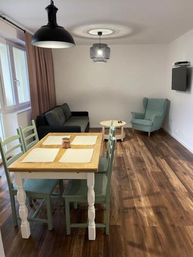 a living room with a table and chairs at Przystań Północy in Suwałki