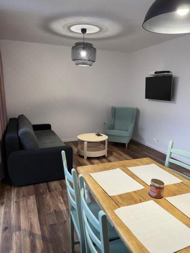 a living room with a table and a couch at Przystań Północy in Suwałki