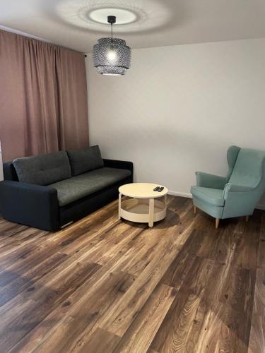 a living room with a couch and two chairs at Przystań Północy in Suwałki