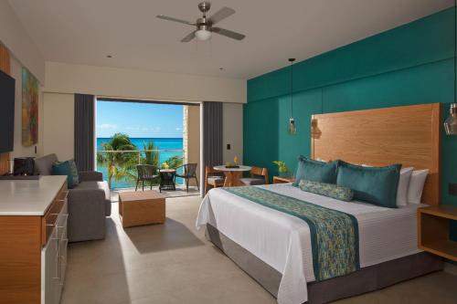 a hotel room with a bed and a view of the ocean at Dreams Cozumel Cape Resort & Spa in Cozumel