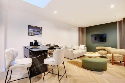 un salon avec un canapé, une table et des chaises dans l'établissement Elegant apartment - 2BR-6P - Le Marais, à Paris