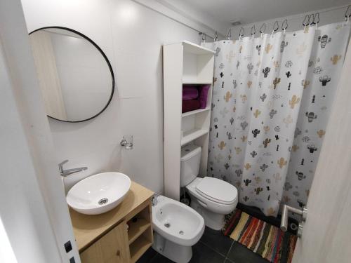 a bathroom with a toilet and a sink and a mirror at Monoambiente céntrico a estrenar in Rosario
