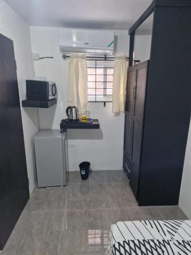 a small room with a kitchen with a microwave at Amharic in Kingston