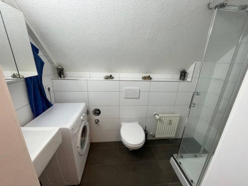 a small bathroom with a toilet and a sink at Schwert Appartment Verden in Verden