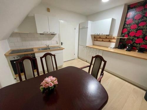 a kitchen with a table with a vase of flowers on it at Schwert Appartment Verden in Verden