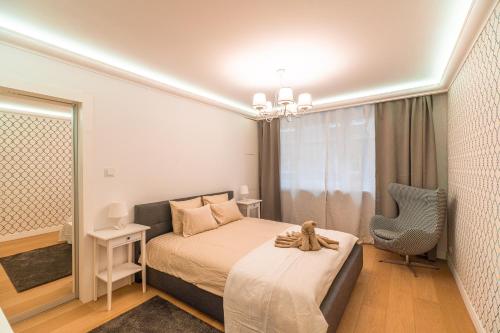 una camera da letto con un letto e un orsacchiotto seduto sopra di Heart of Kraków Comfort Apartments by Rentujemy a Cracovia