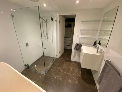 a bathroom with a glass shower and a sink at Garden flat, NORTH SYDNEY in Sydney